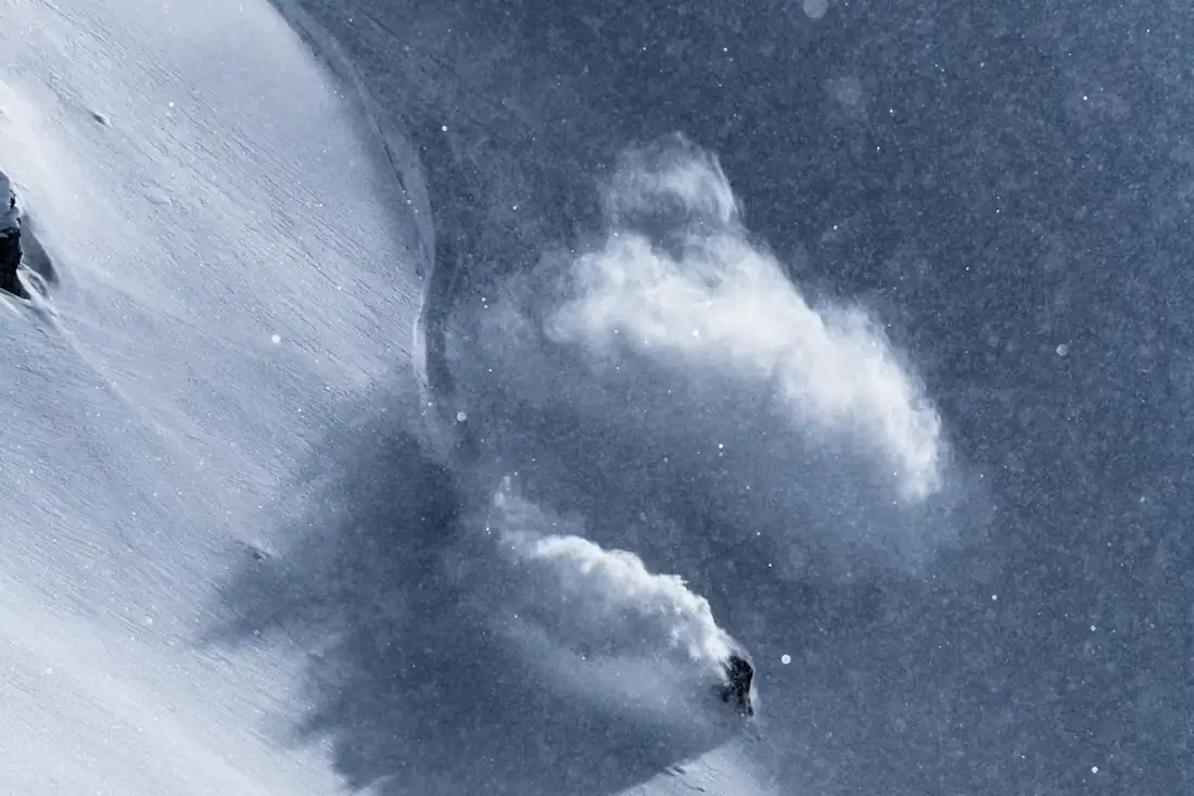 A skier cutting a line across an open snow slope