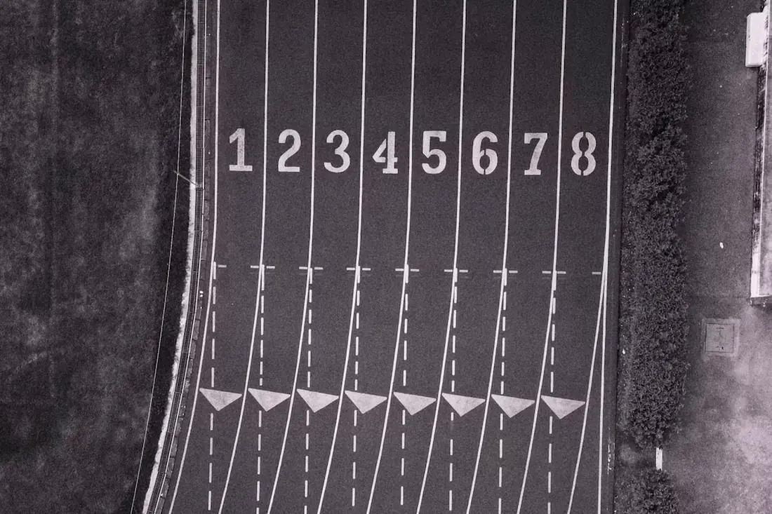An eight-lane running track seen from above, lanes numbered at the start line